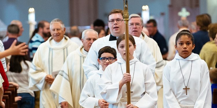 Altar boys holding a cross at a catholic church function. Source-Wikipedia